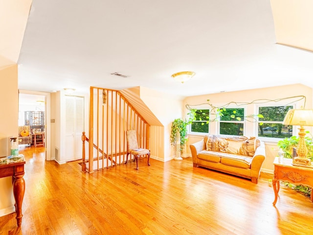 living area featuring visible vents and wood finished floors