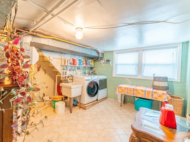 washroom featuring laundry area, washing machine and dryer, a sink, and tile patterned floors