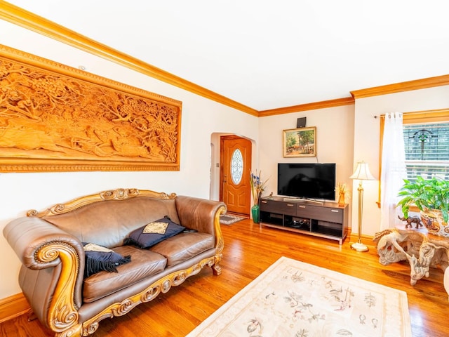 living room featuring arched walkways, baseboards, wood finished floors, and crown molding