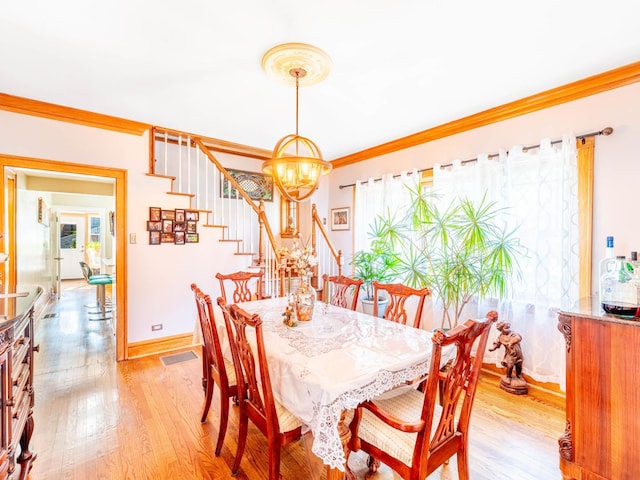 dining area with baseboards, stairway, an inviting chandelier, crown molding, and light wood-type flooring