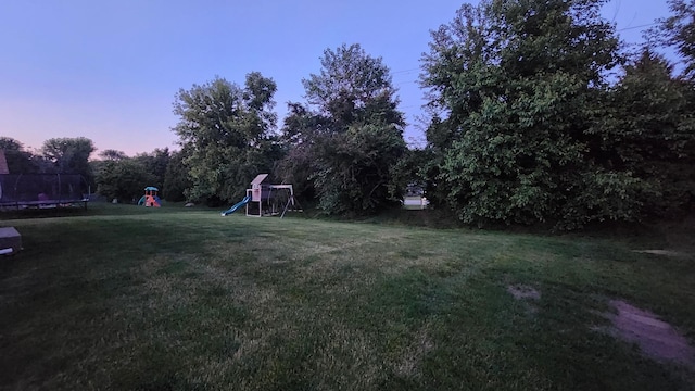 950 Donnelly Pl, Mchenry, IL 60050 - yard at dusk with a trampoline, a playground, and a lawn