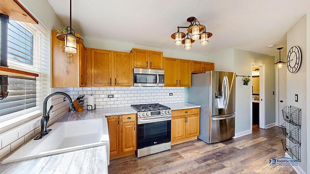 950 Donnelly Pl, Mchenry, IL 60050 - kitchen featuring stainless steel appliances, light countertops, decorative backsplash, wood finished floors, and hanging light fixtures