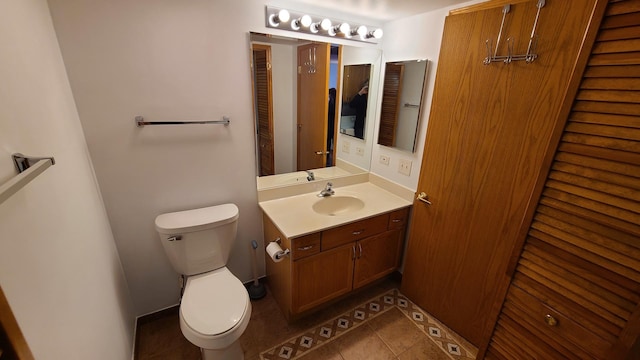 bathroom featuring vanity, a closet, tile patterned flooring, and toilet