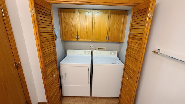 washroom featuring cabinet space and washer and clothes dryer