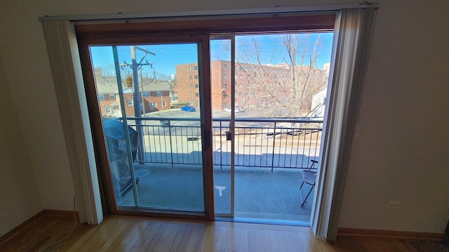 doorway to outside with baseboards and wood finished floors