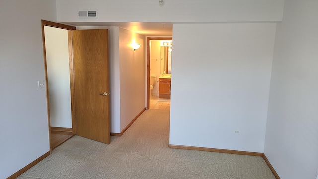 interior space featuring visible vents, light carpet, and baseboards