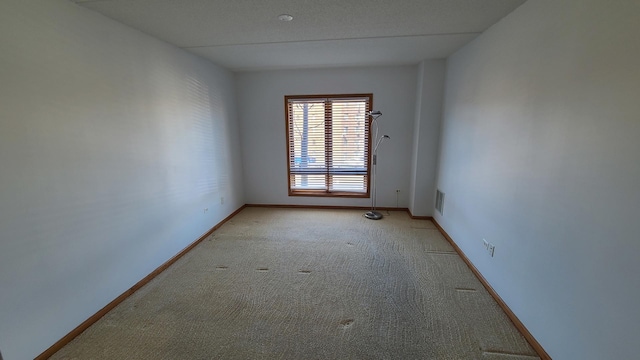 unfurnished room with light colored carpet, visible vents, and baseboards