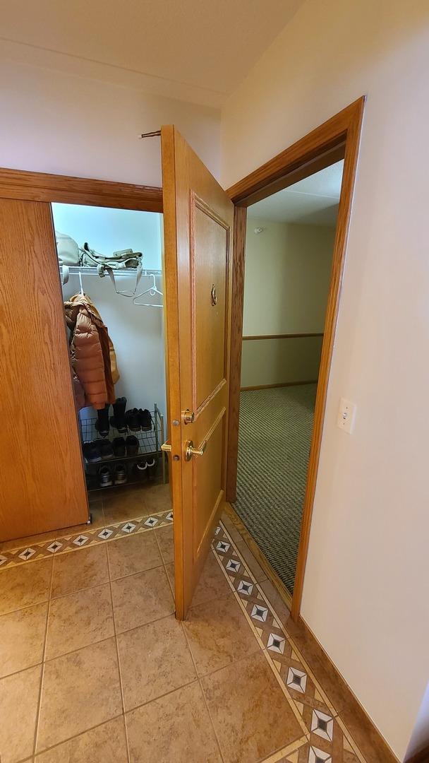 hallway with light tile patterned floors and baseboards