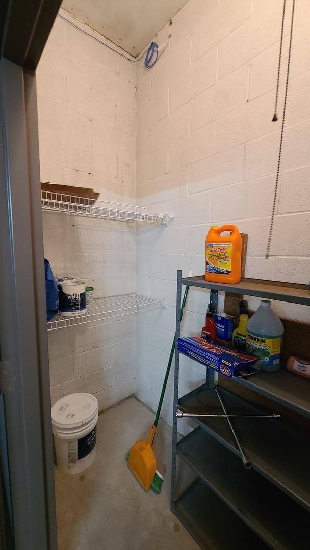 bathroom featuring concrete block wall and unfinished concrete flooring