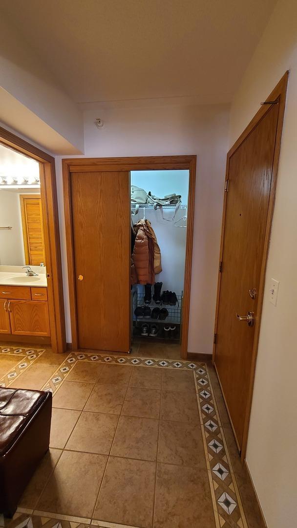 hallway featuring a sink and light tile patterned flooring