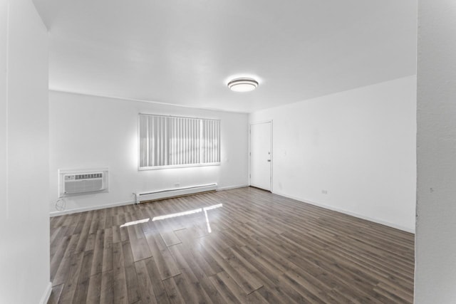 empty room with a wall mounted AC, a baseboard radiator, wood finished floors, and baseboards