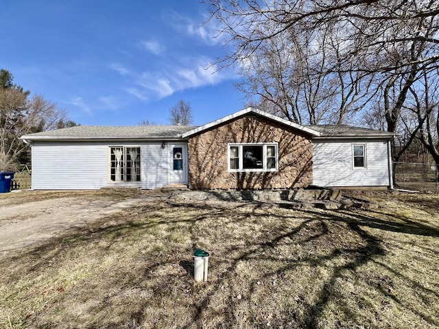 view of front of property featuring stone siding and dirt driveway