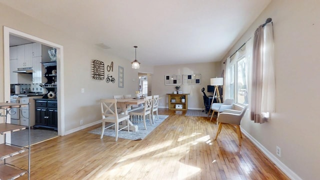 dining room with baseboards and light wood finished floors