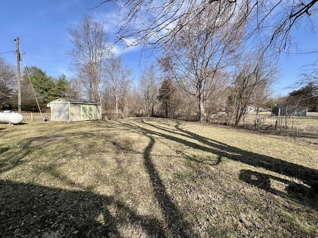 view of yard with a storage shed, an outdoor structure, and fence