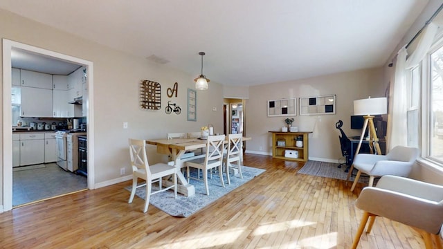 dining space with light wood-style floors and baseboards