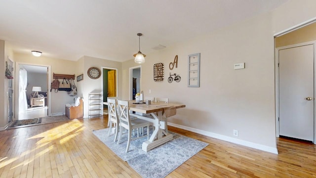 dining space featuring baseboards and wood-type flooring