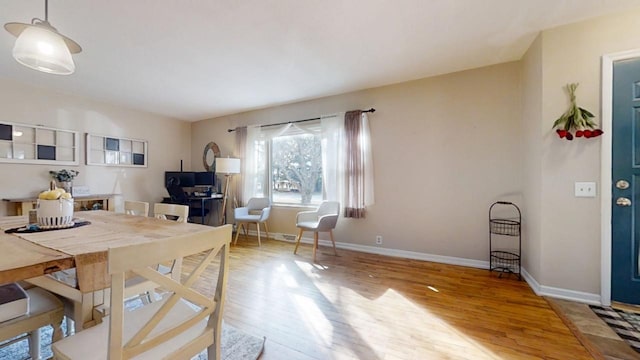 dining space with baseboards and wood finished floors