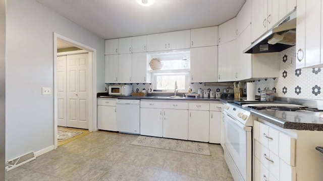 kitchen featuring under cabinet range hood, visible vents, white appliances, and decorative backsplash