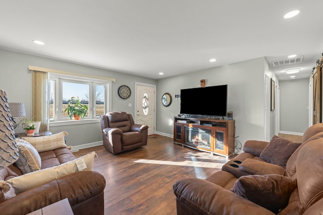 living area featuring baseboards, visible vents, dark wood-style flooring, and recessed lighting