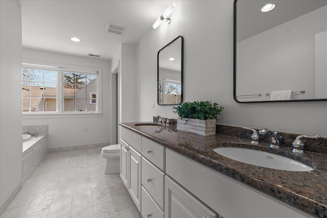 bathroom featuring toilet, a healthy amount of sunlight, and a sink