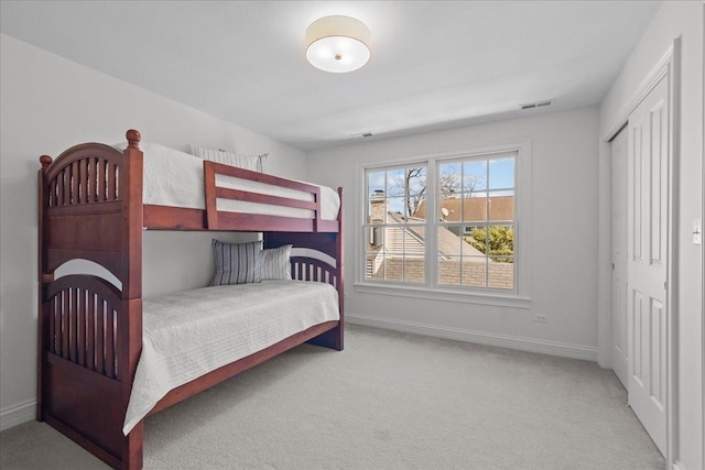 bedroom with visible vents, baseboards, a closet, and carpet