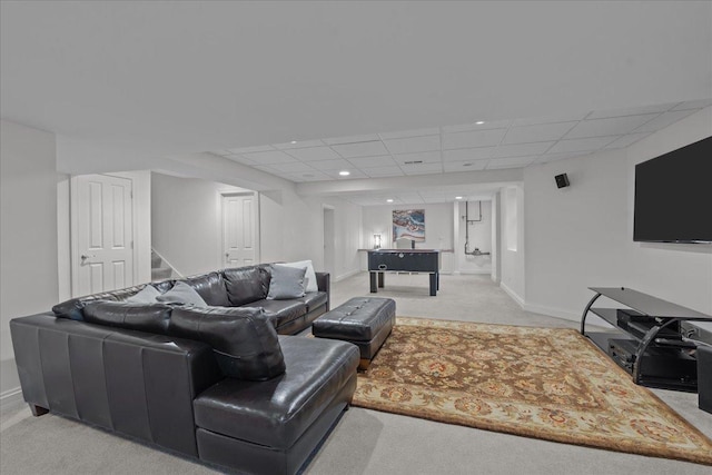 living room with a drop ceiling, baseboards, stairs, and carpet floors