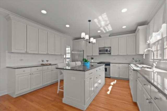 kitchen featuring a kitchen island, light wood-style flooring, white cabinetry, and appliances with stainless steel finishes