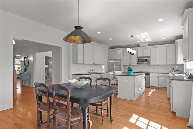 dining space featuring recessed lighting, light wood-style floors, and crown molding