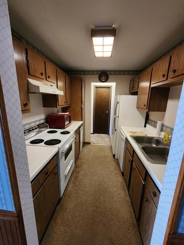 kitchen with white appliances, light countertops, a sink, and under cabinet range hood