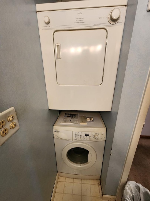 laundry room with laundry area, tile patterned flooring, and stacked washer / dryer