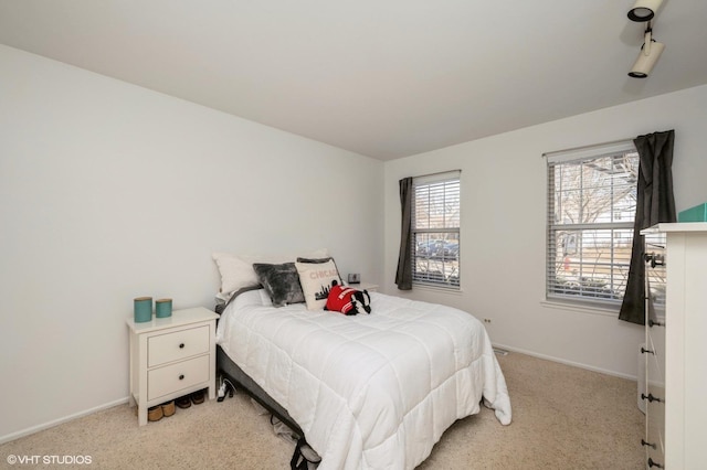 bedroom with light carpet and baseboards