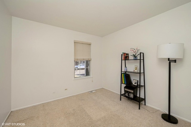 carpeted empty room featuring baseboards and visible vents