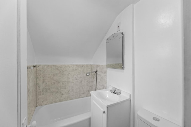 full bathroom featuring toilet, vanity, a washtub, and lofted ceiling