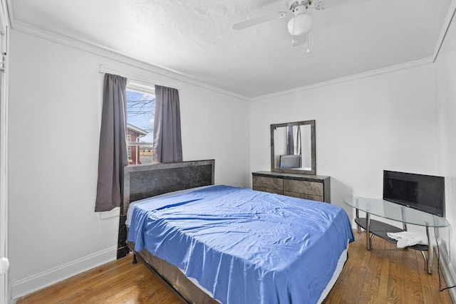 bedroom featuring hardwood / wood-style flooring, baseboards, and crown molding