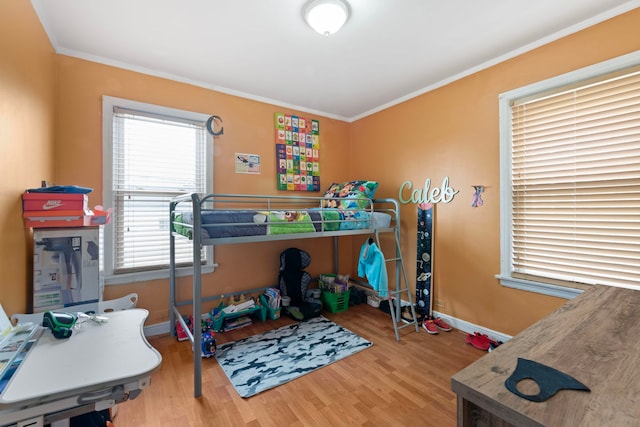 bedroom featuring crown molding, baseboards, and wood finished floors