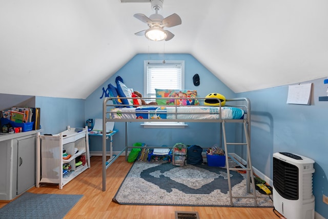 bedroom with baseboards, visible vents, ceiling fan, wood finished floors, and vaulted ceiling