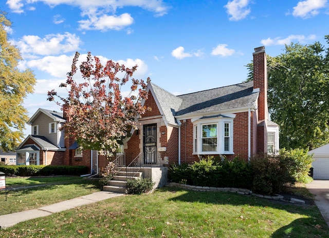 view of front of house with a garage, brick siding, a chimney, and a front lawn