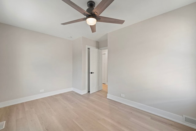 spare room with light wood finished floors, baseboards, visible vents, and ceiling fan