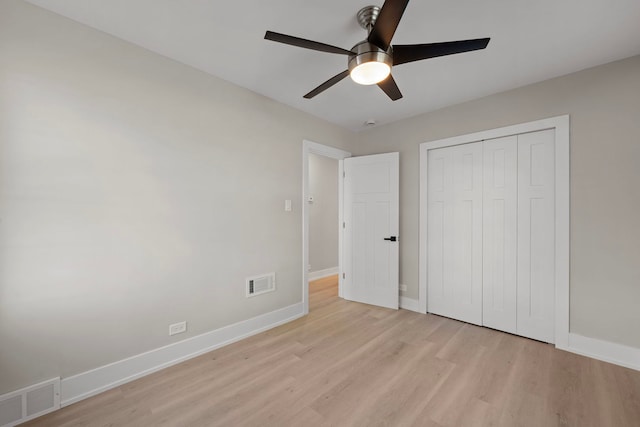 unfurnished bedroom with a closet, visible vents, light wood finished floors, and baseboards