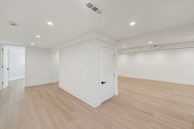 finished below grade area featuring recessed lighting, visible vents, light wood-style flooring, and baseboards