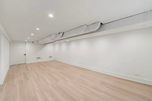 finished basement featuring light wood-type flooring, baseboards, visible vents, and recessed lighting