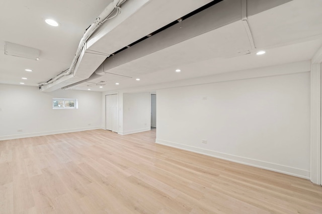 below grade area with light wood finished floors, baseboards, and recessed lighting