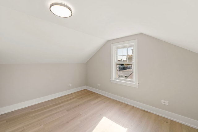 additional living space featuring lofted ceiling, light wood-style flooring, and baseboards