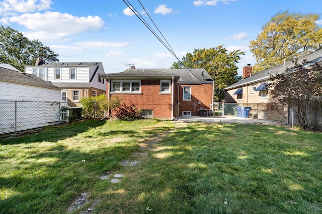 rear view of house with a fenced backyard, a patio, and brick siding