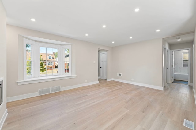 unfurnished living room featuring light wood-type flooring, visible vents, and recessed lighting