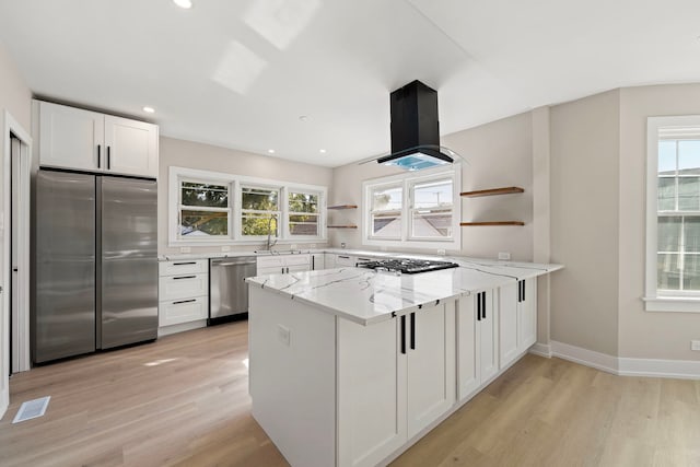 kitchen featuring light stone counters, open shelves, visible vents, appliances with stainless steel finishes, and island range hood