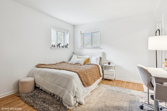 bedroom with light wood-type flooring and baseboards