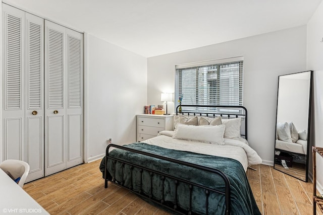 bedroom featuring a closet, baseboards, and light wood-style flooring