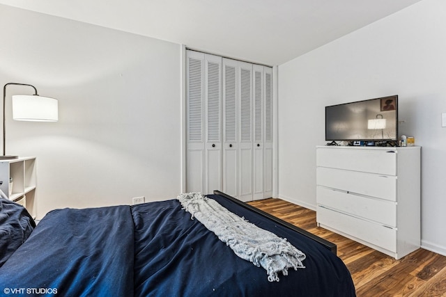 bedroom featuring wood finished floors, a closet, and baseboards