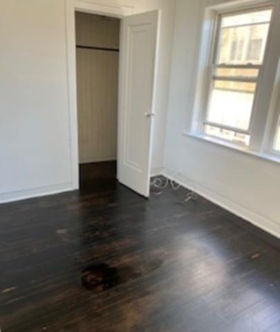 unfurnished bedroom with dark wood-style floors, a closet, and baseboards